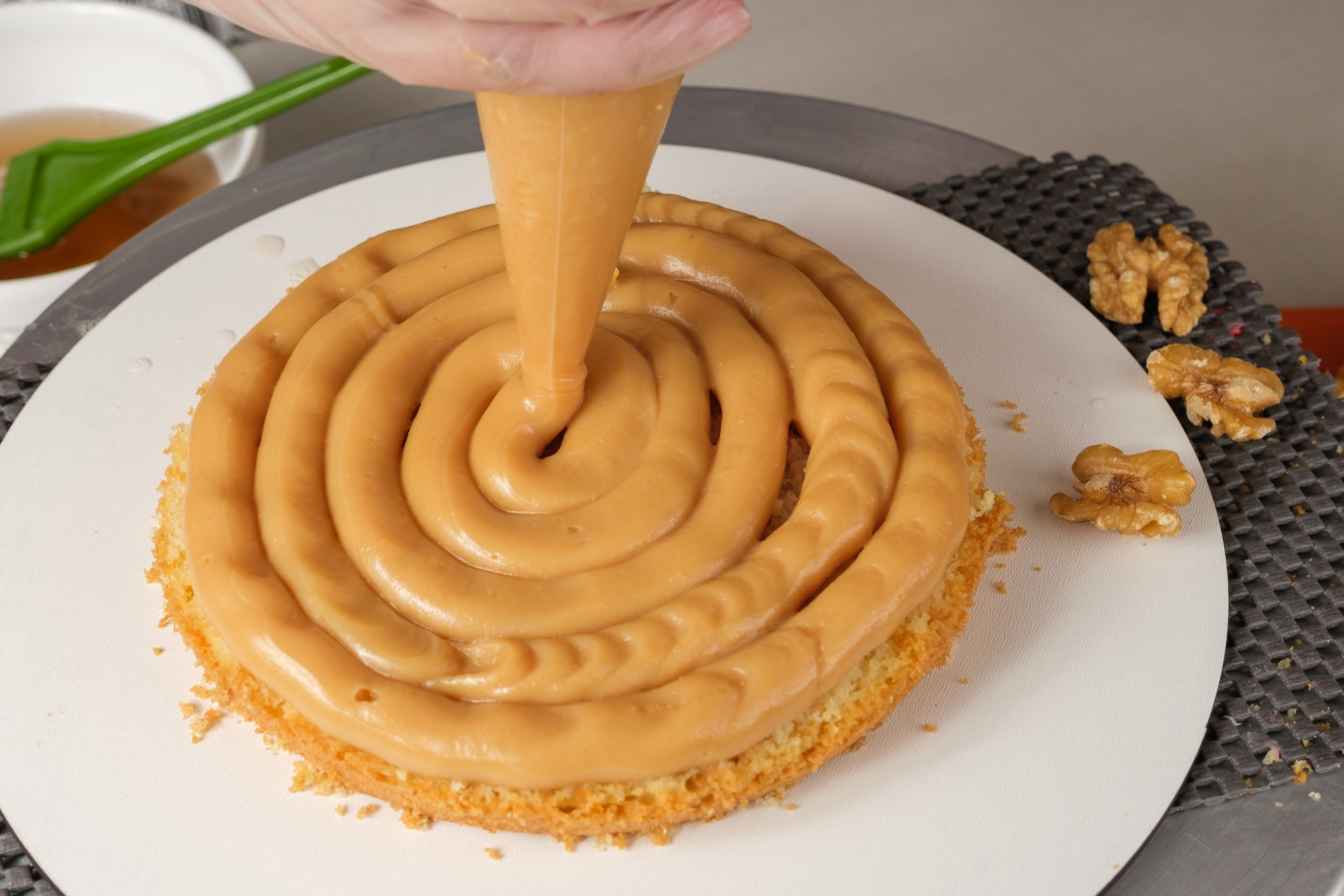 Confectioner finishing the cake filling with dulce de leche brigadeiro.